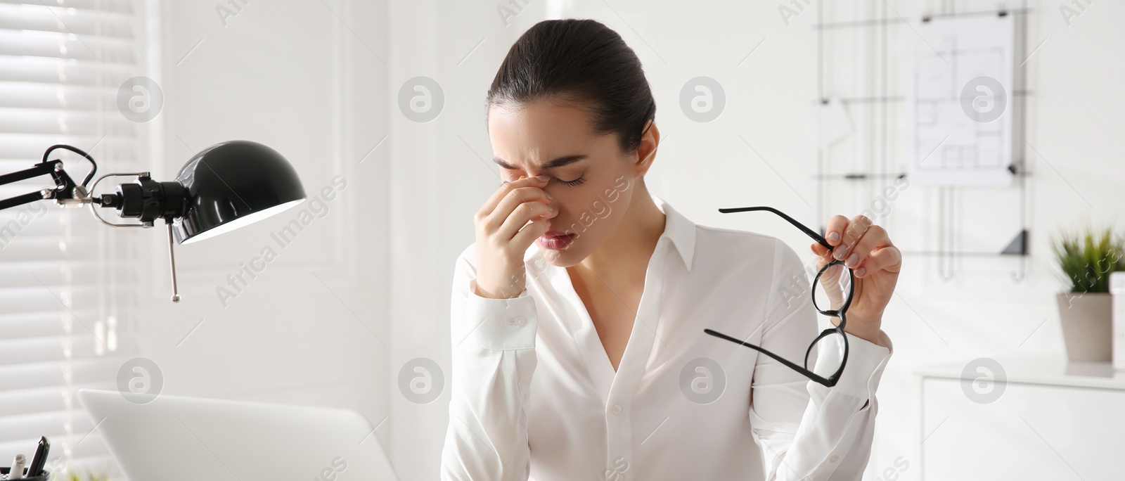 Image of Stressed and tired young woman with headache at workplace. Banner design