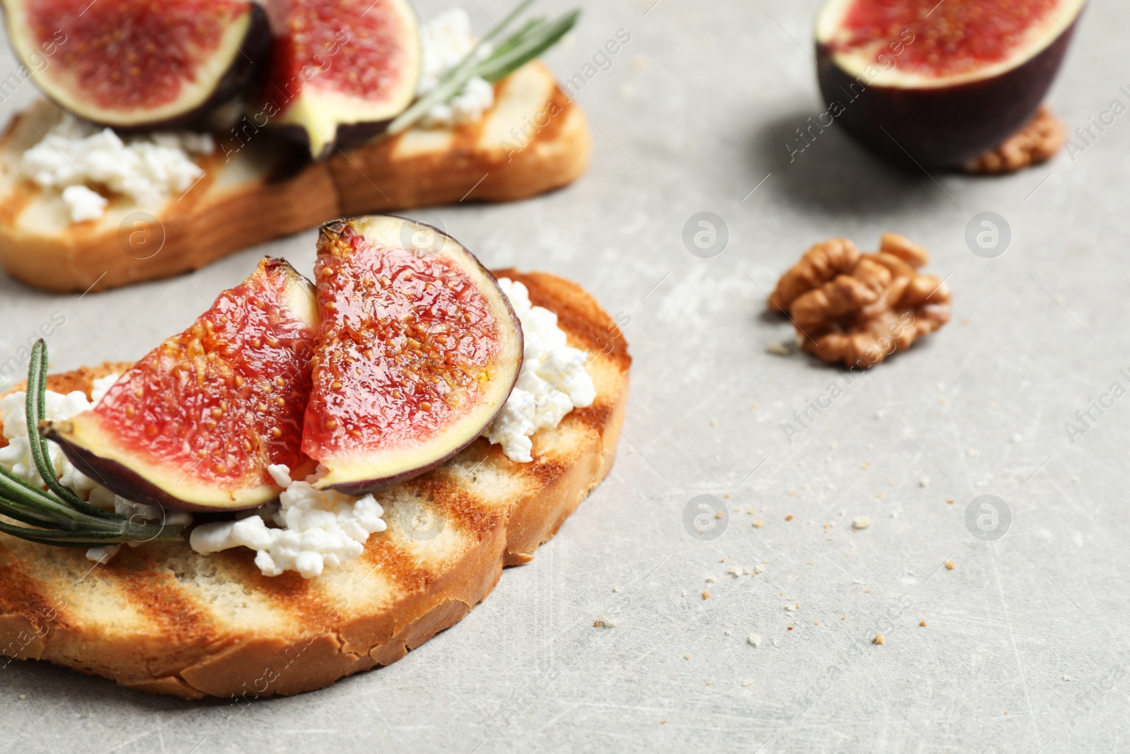 Photo of Bruschettas with ripe figs and cheese on light table, closeup