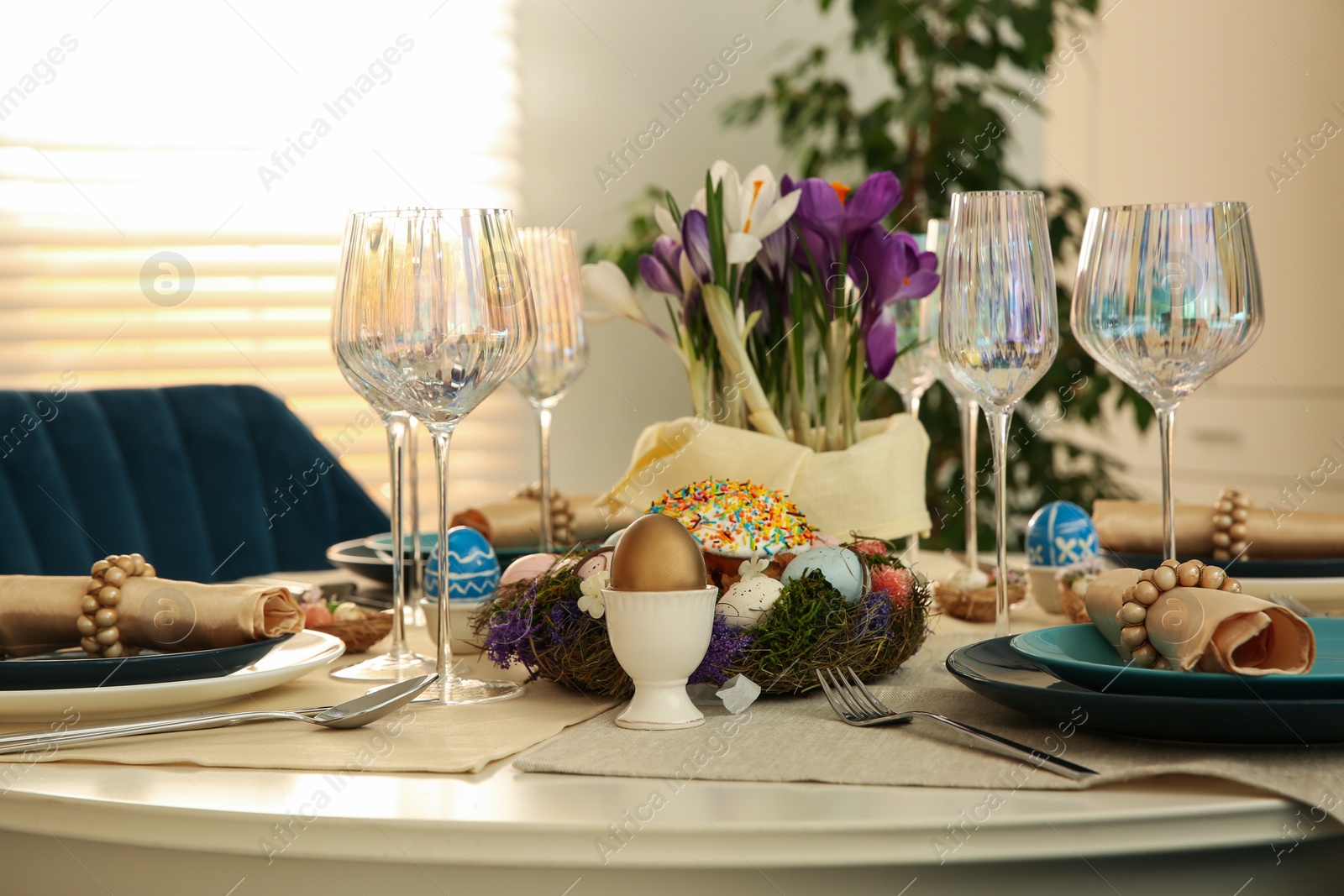 Photo of Festive Easter table setting with decorated eggs in kitchen