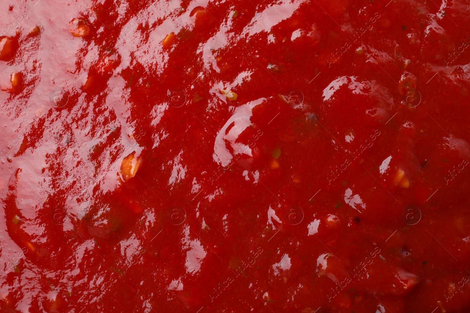 Photo of Tasty red spicy sauce as background, closeup