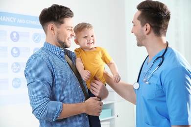 Photo of Father with child visiting doctor in hospital