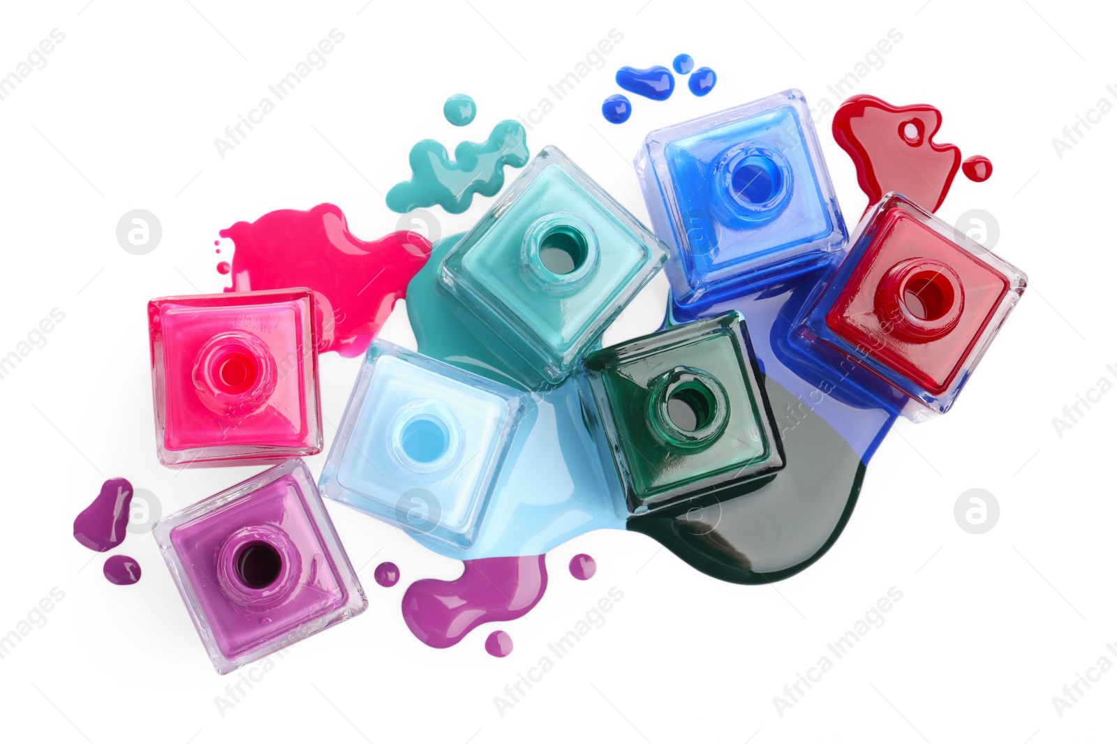 Photo of Drops of different bright nail polishes and bottles isolated on white, top view