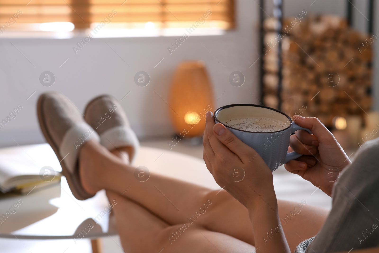 Photo of Woman with cup of aromatic coffee relaxing at home, closeup