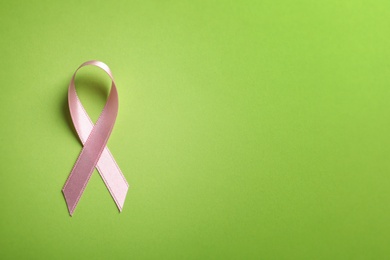 Photo of Pink ribbon on color background, top view. Cancer awareness