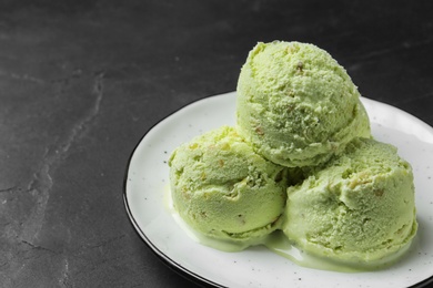 Photo of Delicious pistachio ice cream on dark table