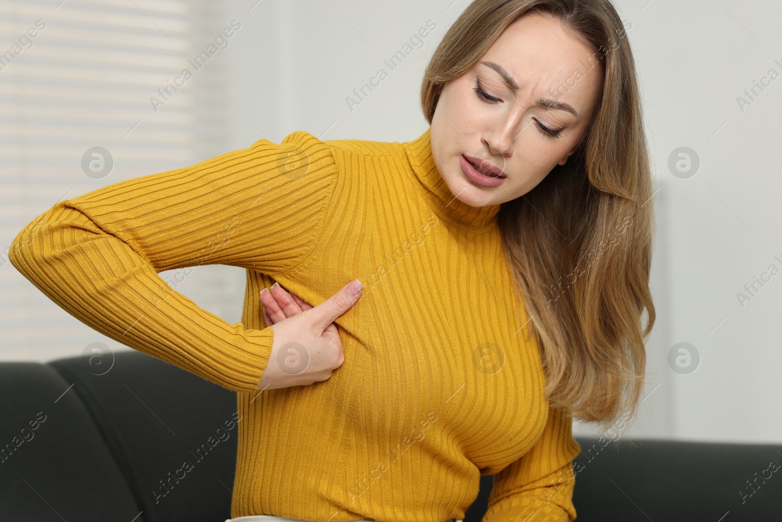 Photo of Mammology. Young woman doing breast self-examination at home