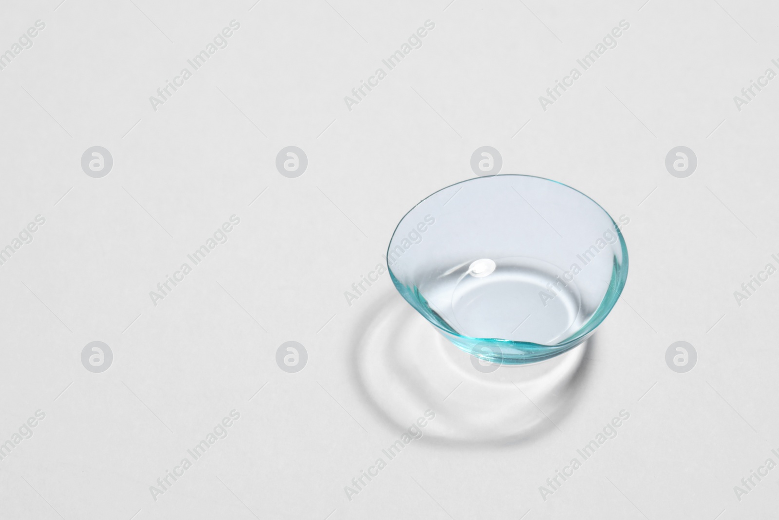 Photo of One contact lens on white background, space for text