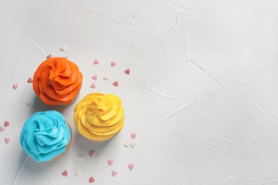Photo of Delicious birthday cupcakes on light background