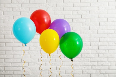 Bright balloons near brick wall. Celebration time