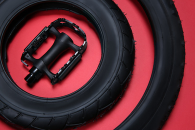 Photo of Bicycle tires and pedal on red background, closeup