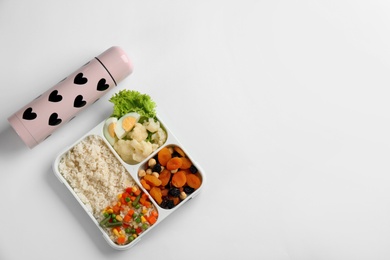 Photo of Thermos and lunch box with food on white background, top view