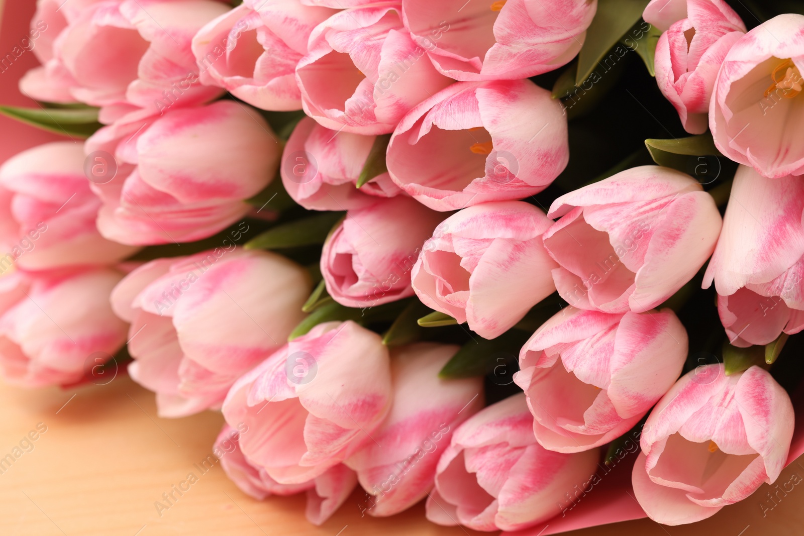 Photo of Beautiful bouquet of fresh pink tulips on table, closeup