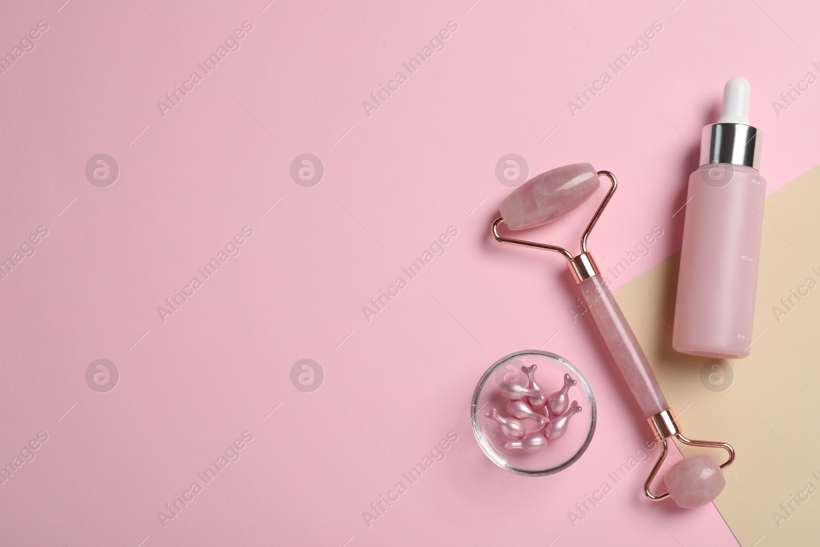 Photo of Face roller and skin care products on color background, flat lay. Space for text