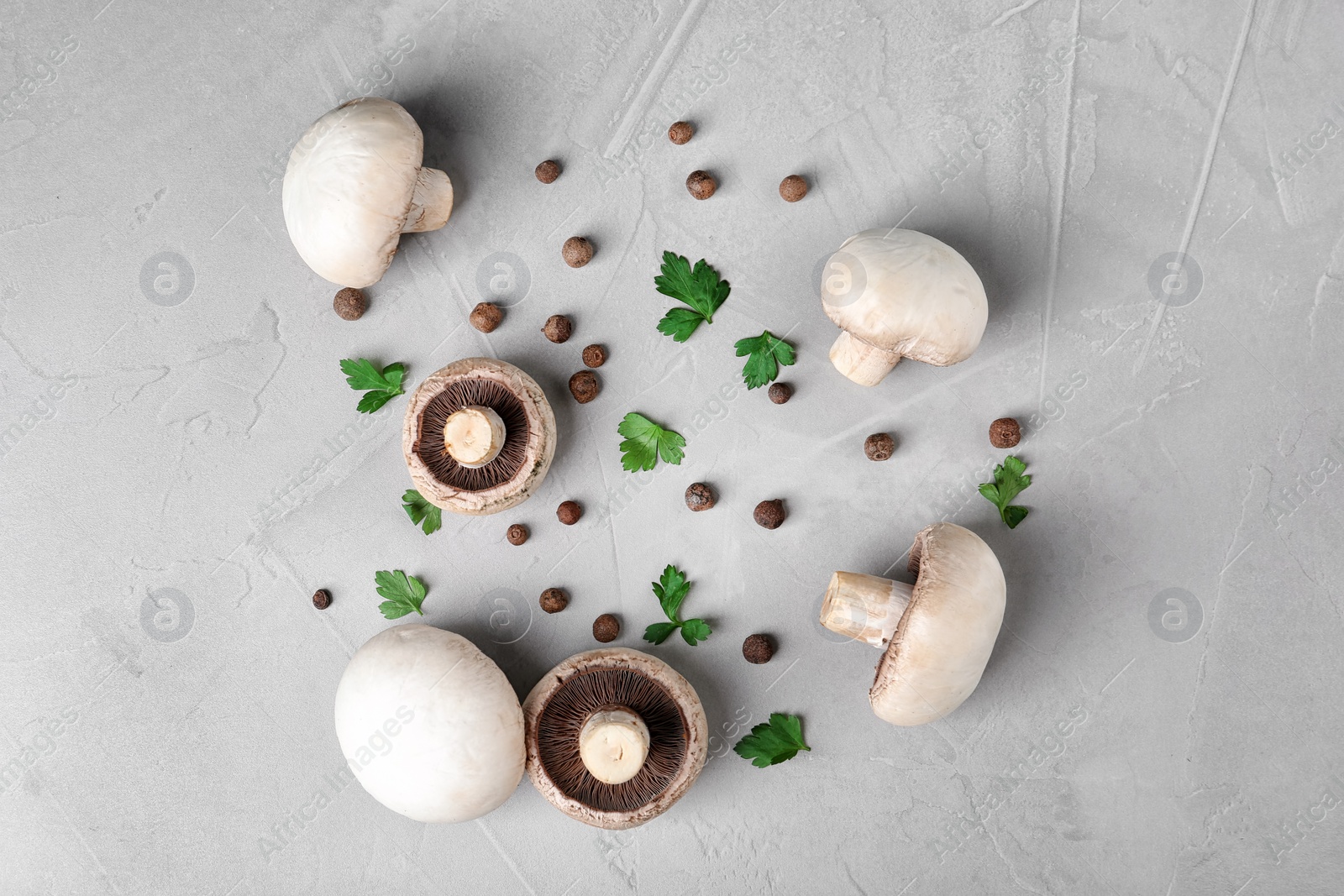 Photo of Flat lay composition with fresh champignon mushrooms on grey background