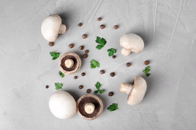 Flat lay composition with fresh champignon mushrooms on grey background