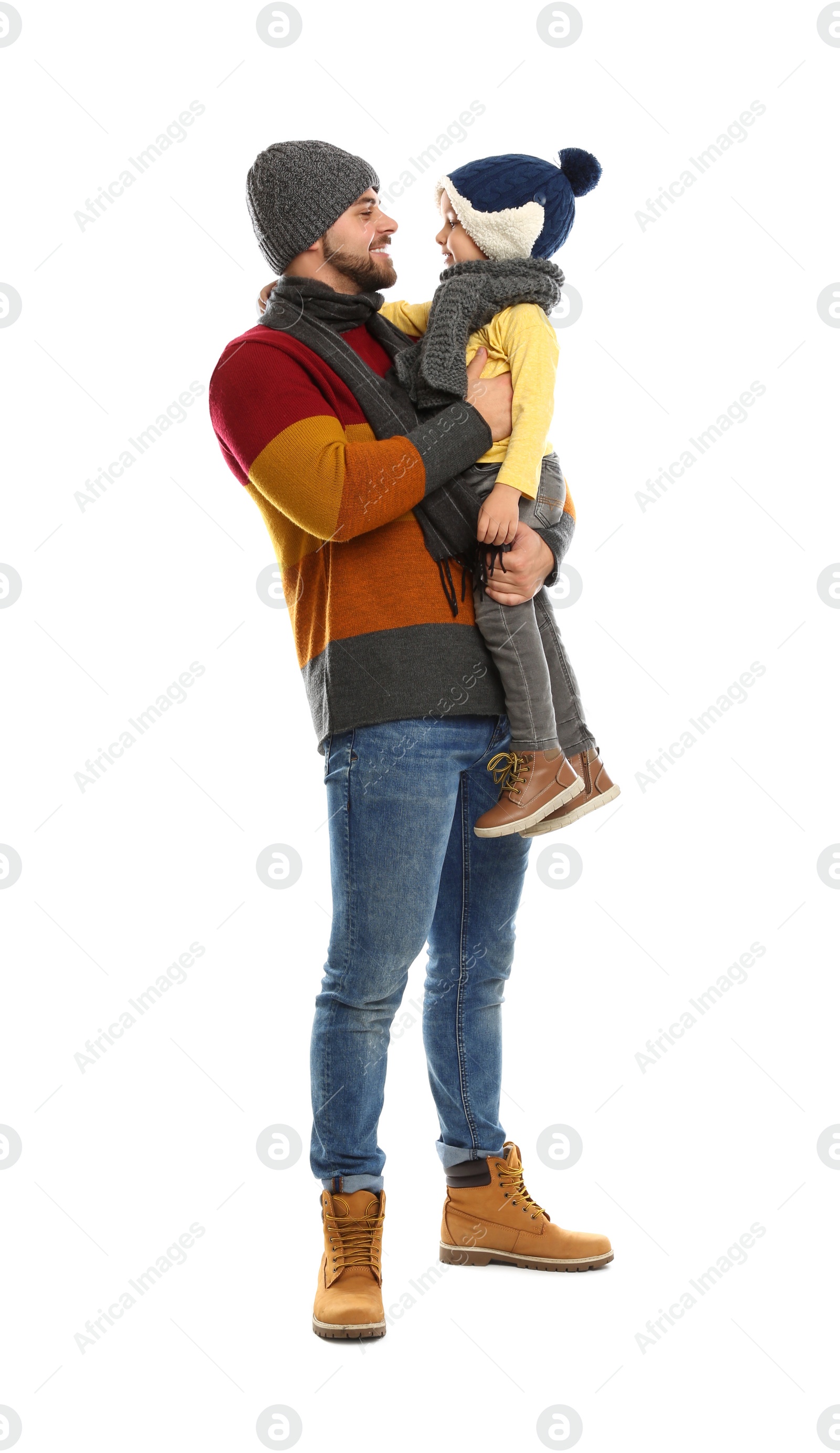 Photo of Happy father and son in warm clothes on white background. Winter vacation