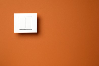 Photo of White light switch on color background, top view. Space for text