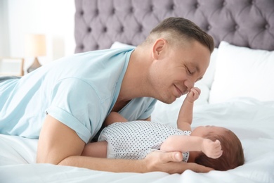 Man with his newborn baby on bed