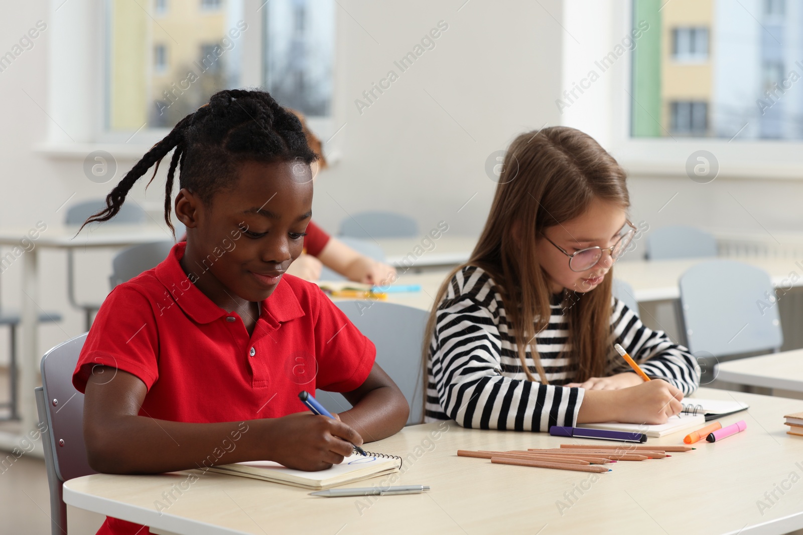 Photo of Cute children studying in classroom at school