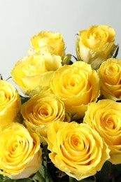 Beautiful bouquet of yellow roses on light grey background, closeup