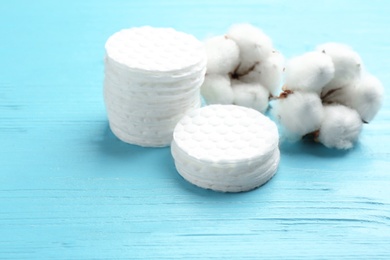 Photo of Composition with cotton pads and flowers on wooden background. Space for text