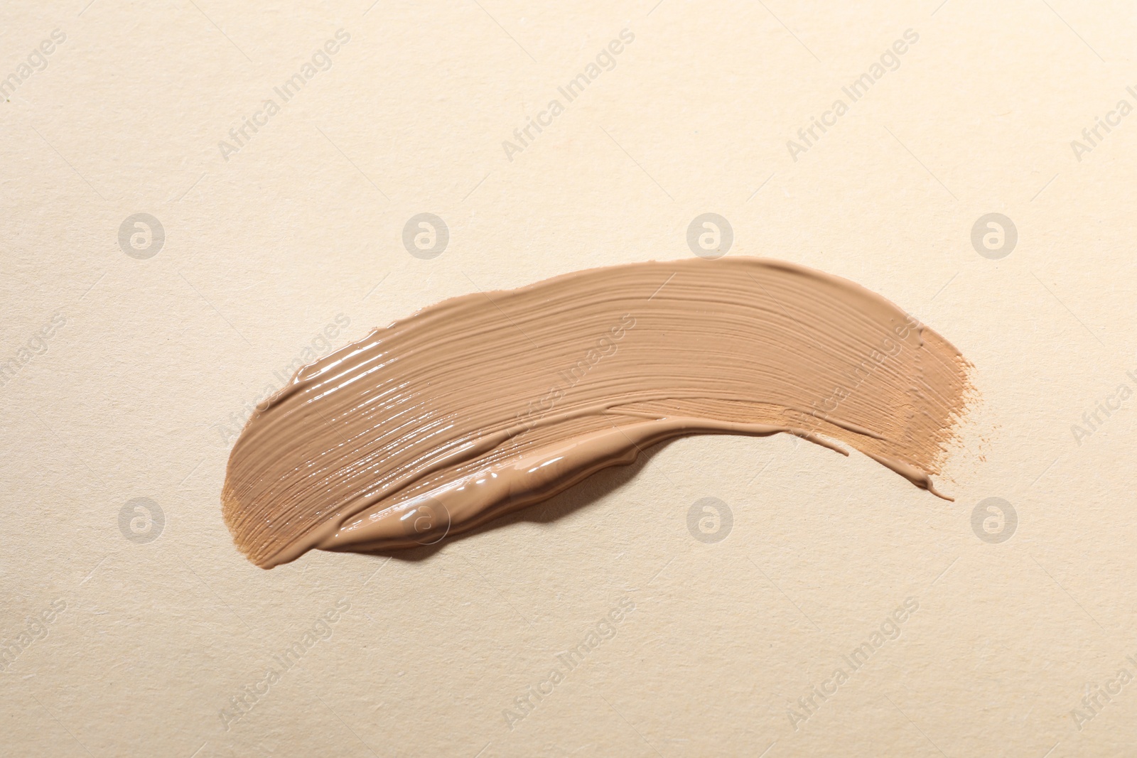 Photo of Swatch of skin foundation on beige background, top view