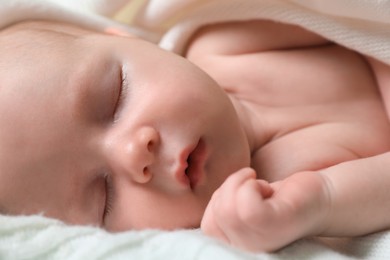 Cute newborn baby sleeping on white blanket, closeup