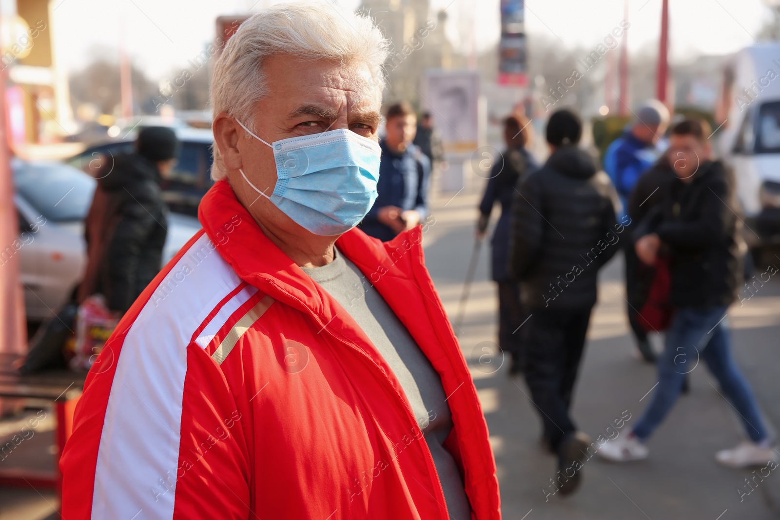 Photo of Senior man with medical mask on city street. Virus protection