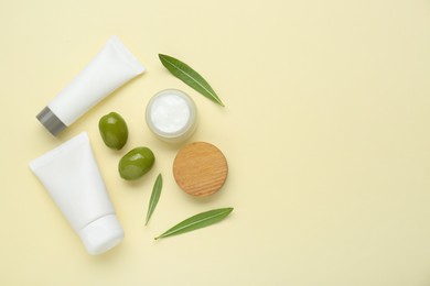 Photo of Cosmetic products with olive essential oil on beige background, flat lay. Space for text