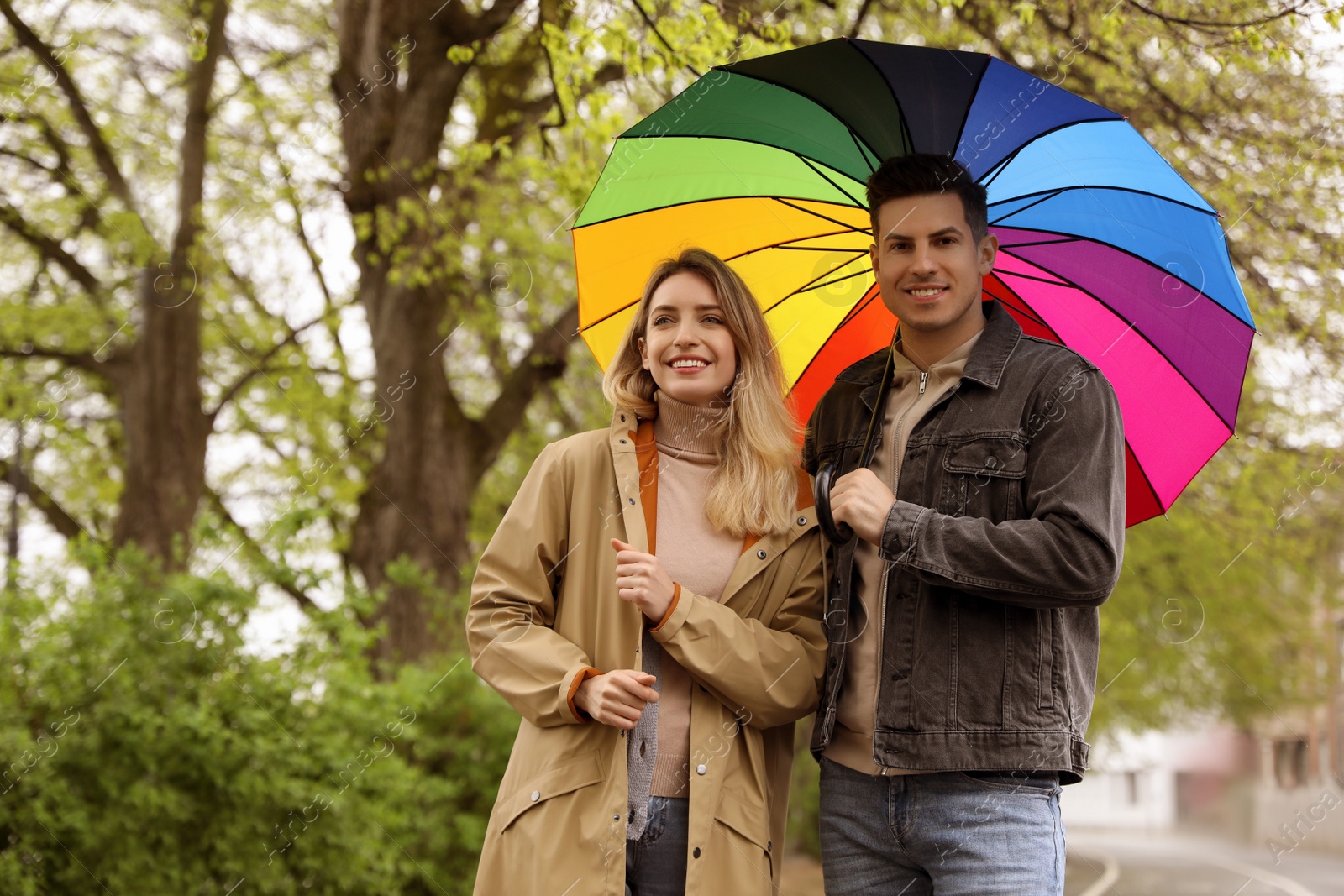 Photo of Lovely couple with umbrella walking on spring day