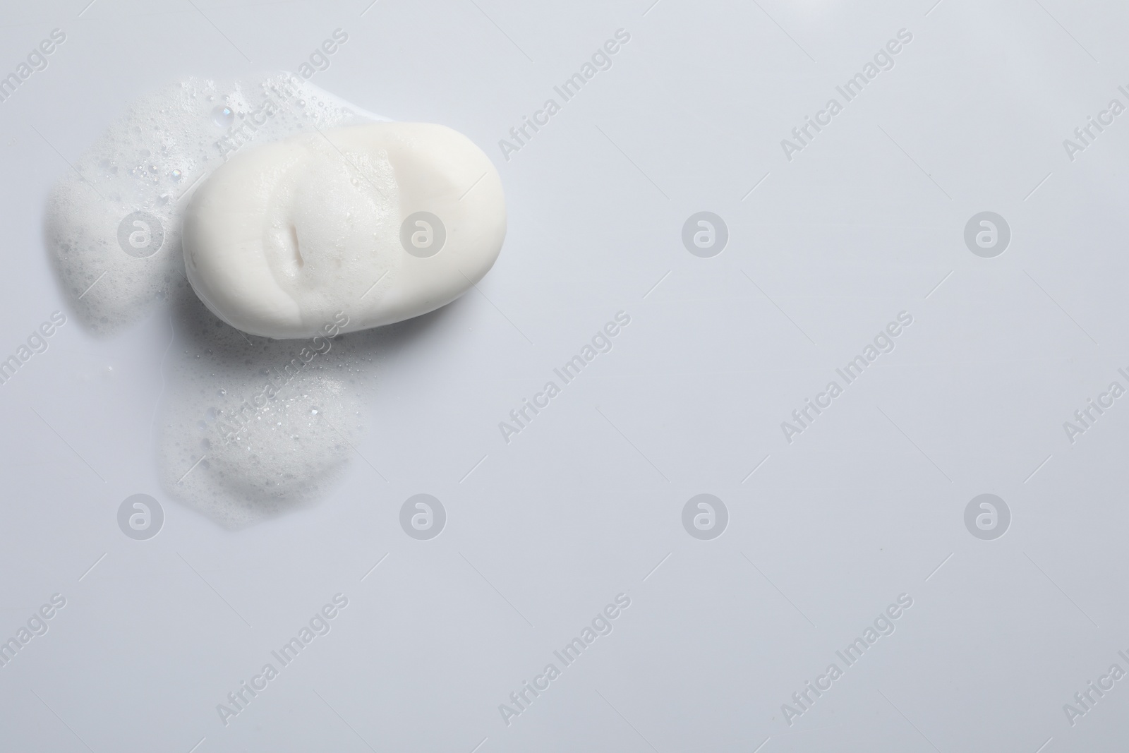 Photo of Soap and fluffy foam on white background, top view