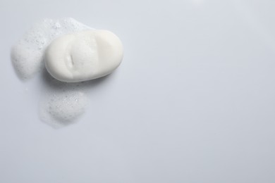 Photo of Soap and fluffy foam on white background, top view