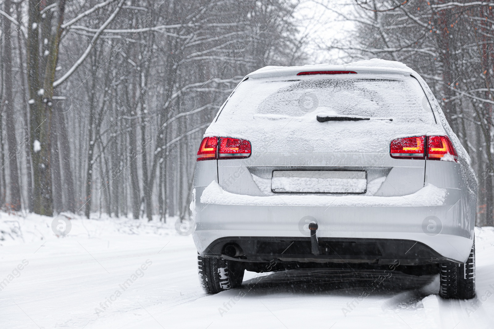 Photo of Car with winter tires on snowy road in forest, space for text