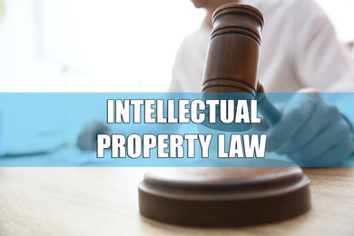 Image of Intellectual property law. Judge with gavel at table, closeup