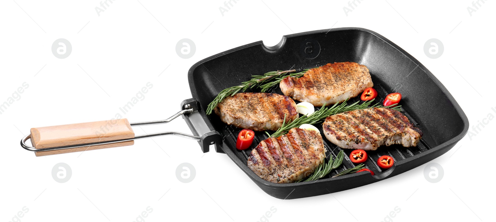 Photo of Grill pan with delicious pork steaks, garlic, chili pepper and rosemary isolated on white