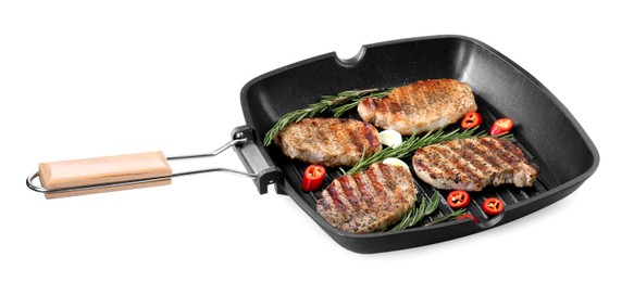 Grill pan with delicious pork steaks, garlic, chili pepper and rosemary isolated on white