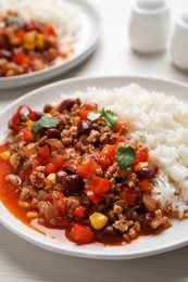 Photo of Plate of rice with chili con carne on white wooden table