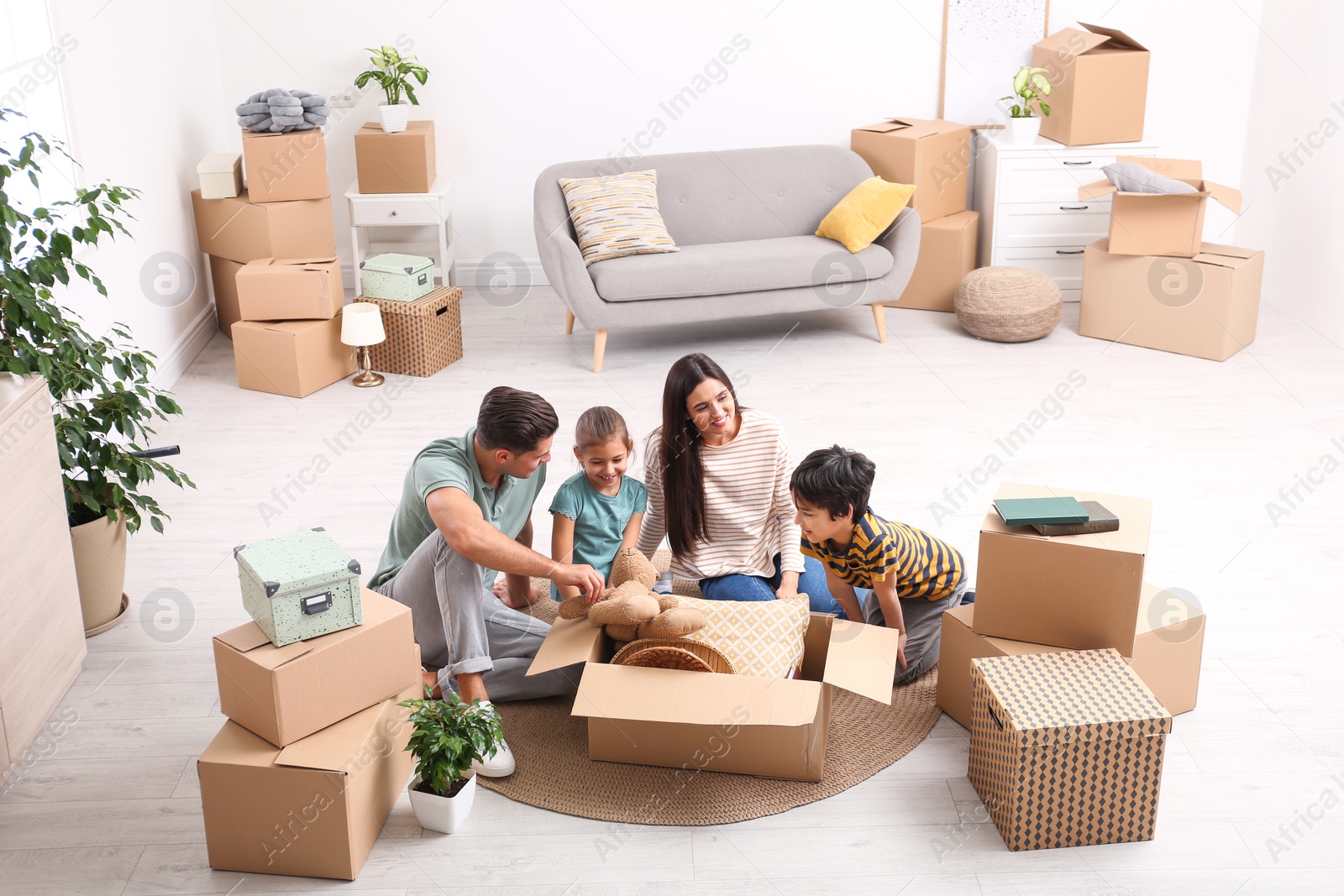 Photo of Happy family unpacking moving boxes at their new home