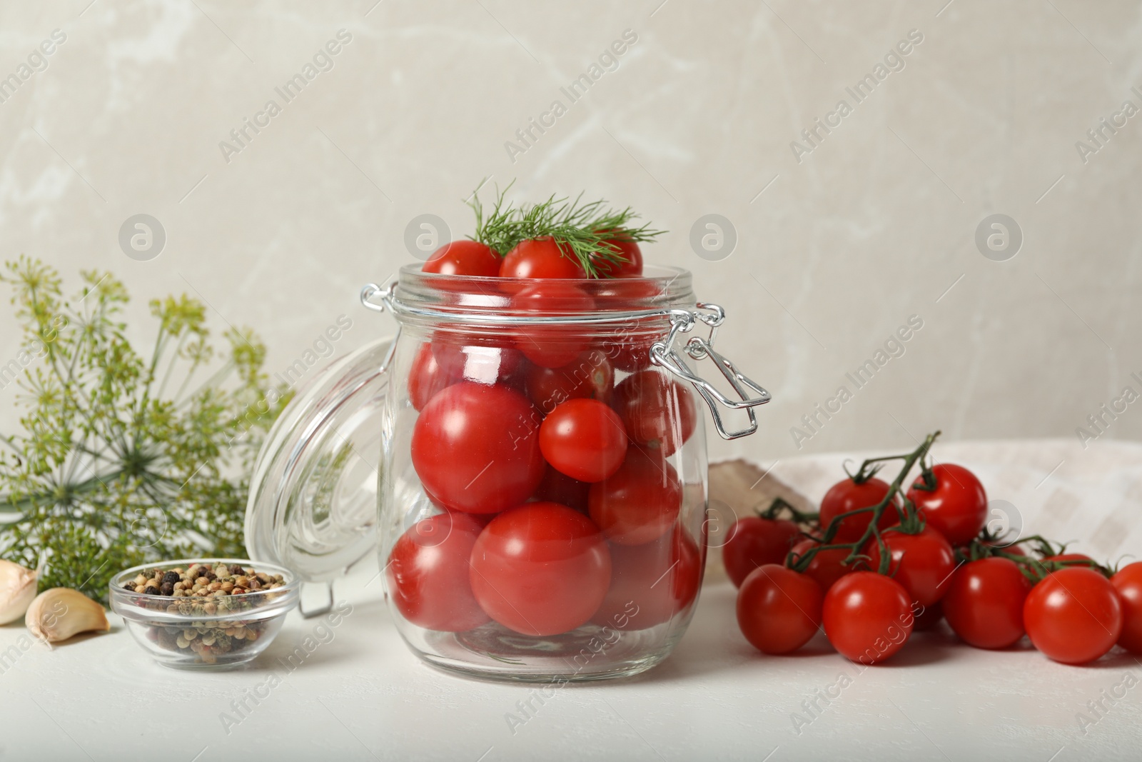 Photo of Pickling jar with fresh tomatoes on white table
