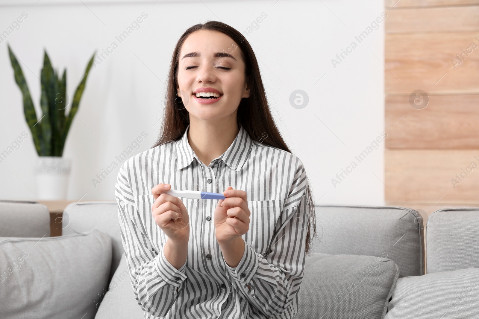 Photo of Young woman with pregnancy test at home. Gynecology and childbirth