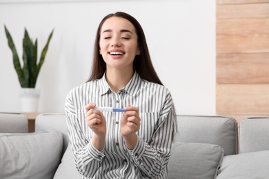 Photo of Young woman with pregnancy test at home. Gynecology and childbirth