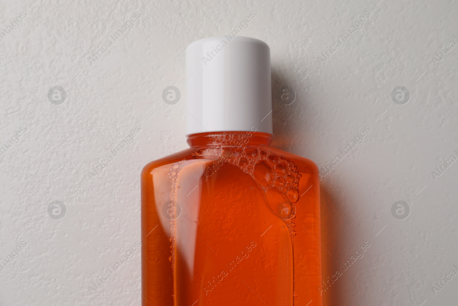 Photo of Fresh mouthwash in bottle on white background, top view
