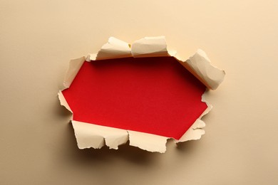 Hole in light beige paper on red background