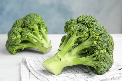 Photo of Fresh green broccoli on white wooden table, closeup