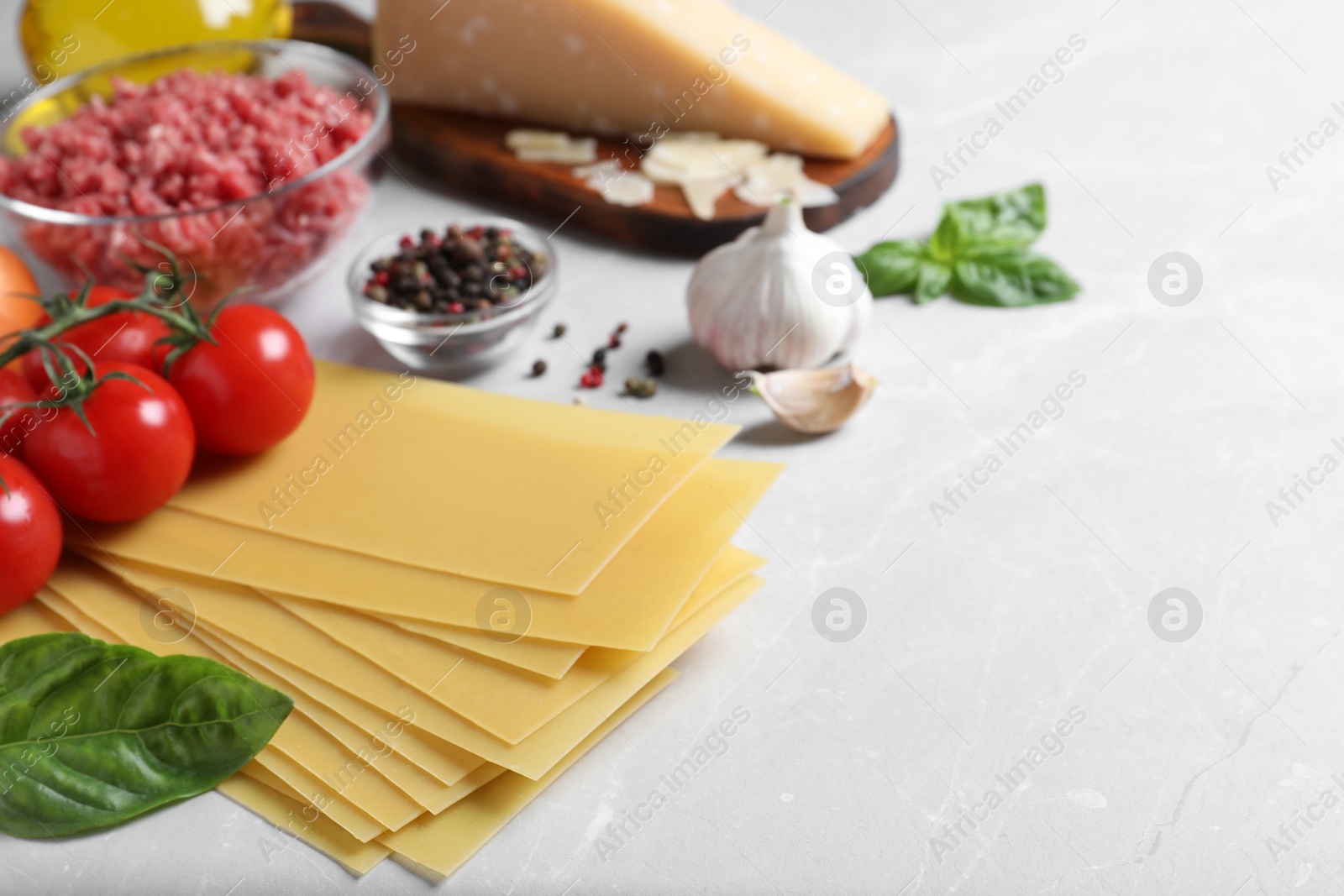 Photo of Fresh ingredients for lasagna on light grey marble table