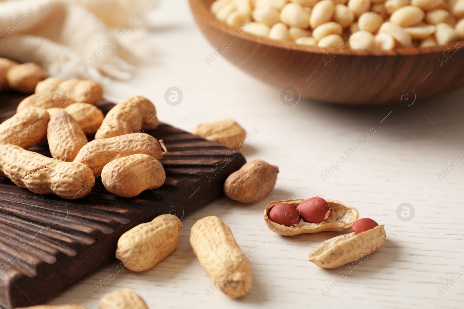 Photo of Raw peanuts in shell and board on table