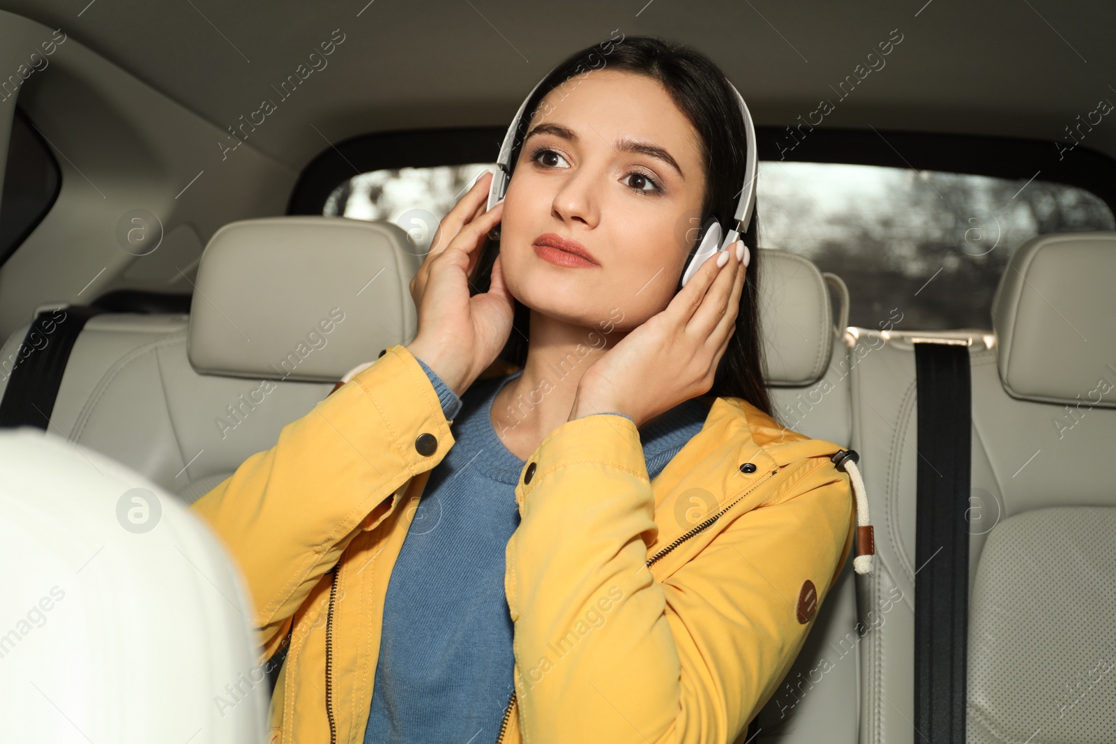 Photo of Young woman listening to audiobook in car