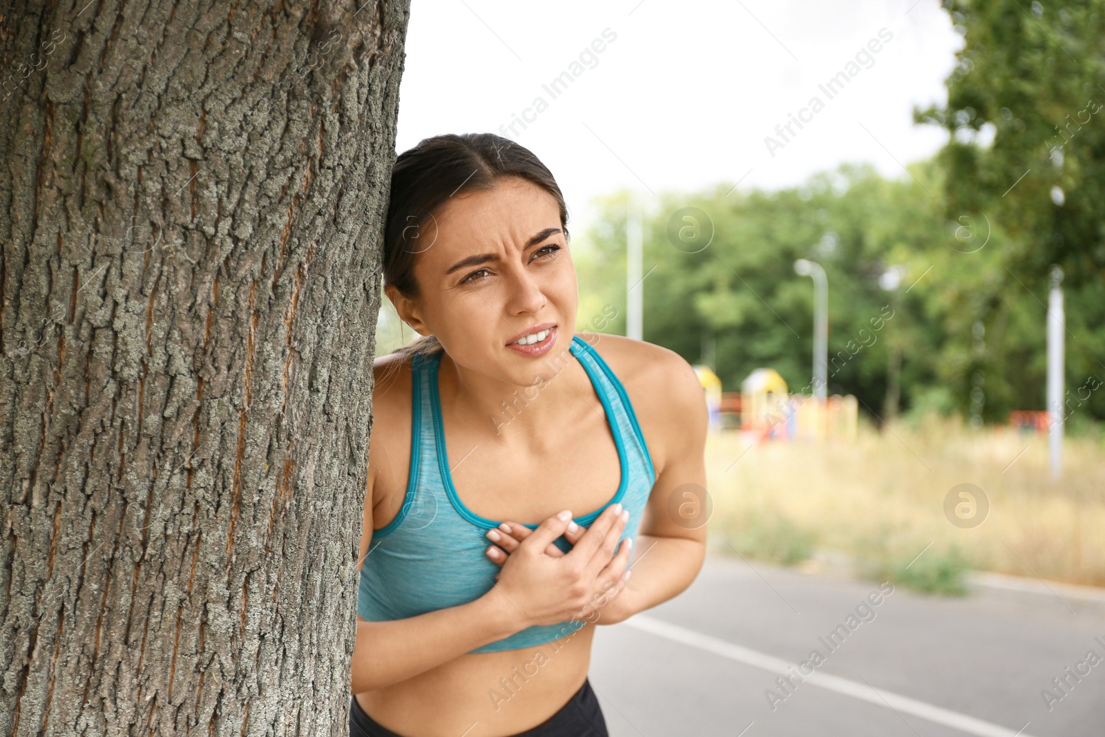 Photo of Young woman having heart attack while running outdoors