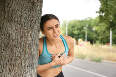 Photo of Young woman having heart attack while running outdoors