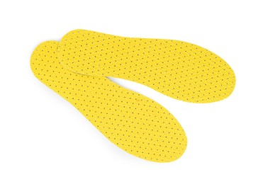 Pair of yellow orthopedic insoles on white background, top view